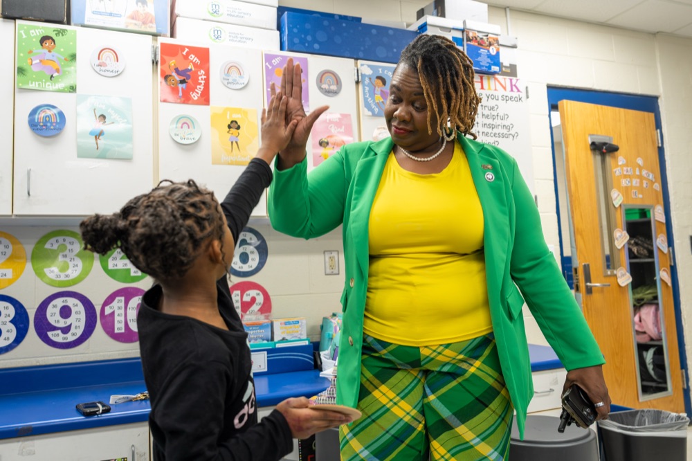 Tyra Little giving a young student a high five